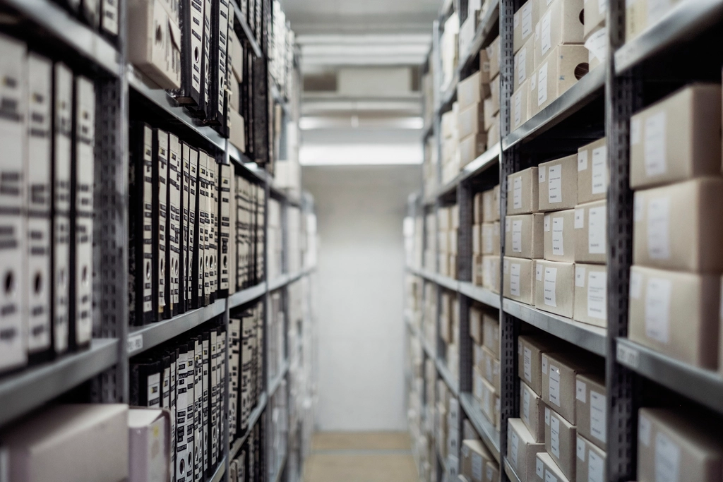 Archive shelving stacked with document boxes receding into depth